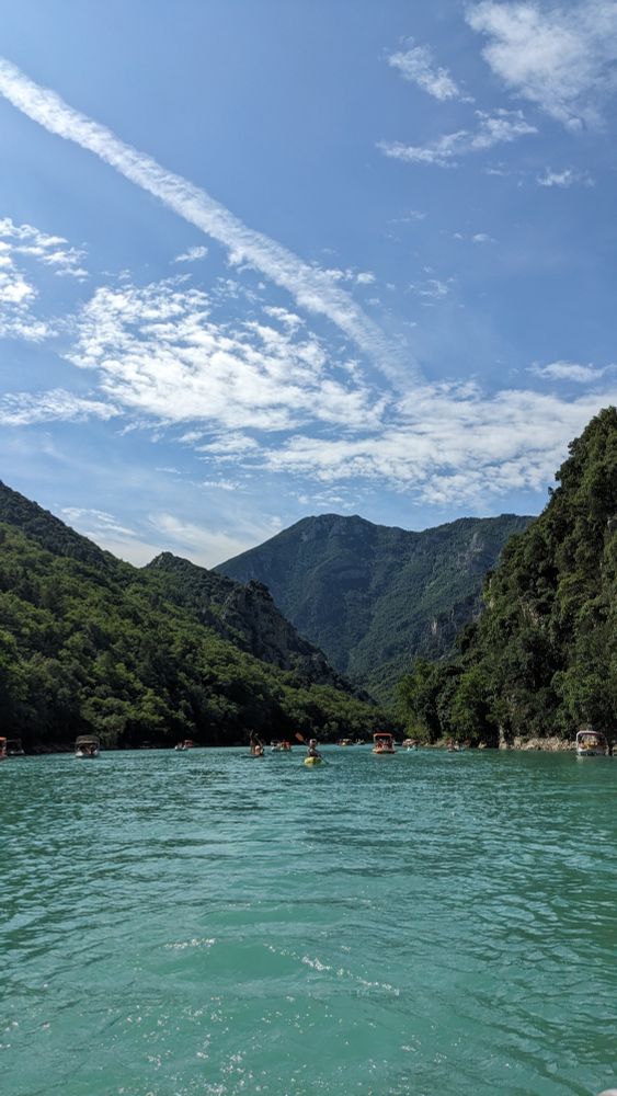 Photo of a beautiful jade coloured river flowing through high mountains covered in rich vegetation and trees. The location is the Verdon Gorge in the south of France.