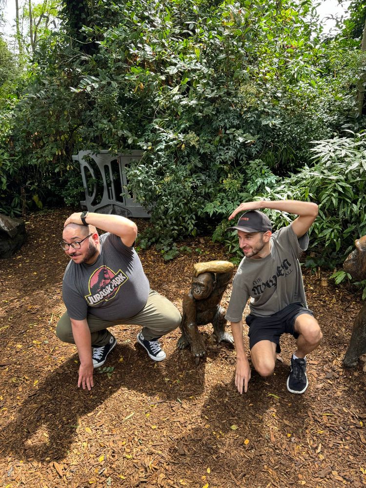 Two homos copying a gorilla statue at the woodland park zoo.