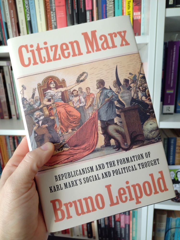 Book held in front of bookshelf. Bruno Leipold "Citizen Marx".