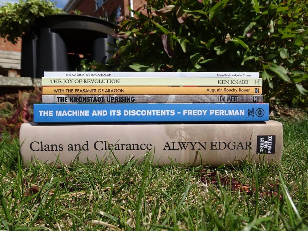 A pile of books stacked up on a lawn.
