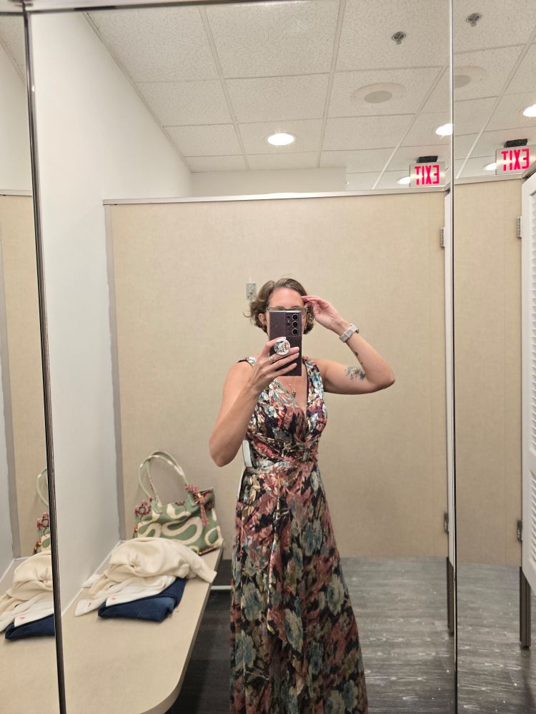 In a dressing room, i am wearing a long shimmery dress. 