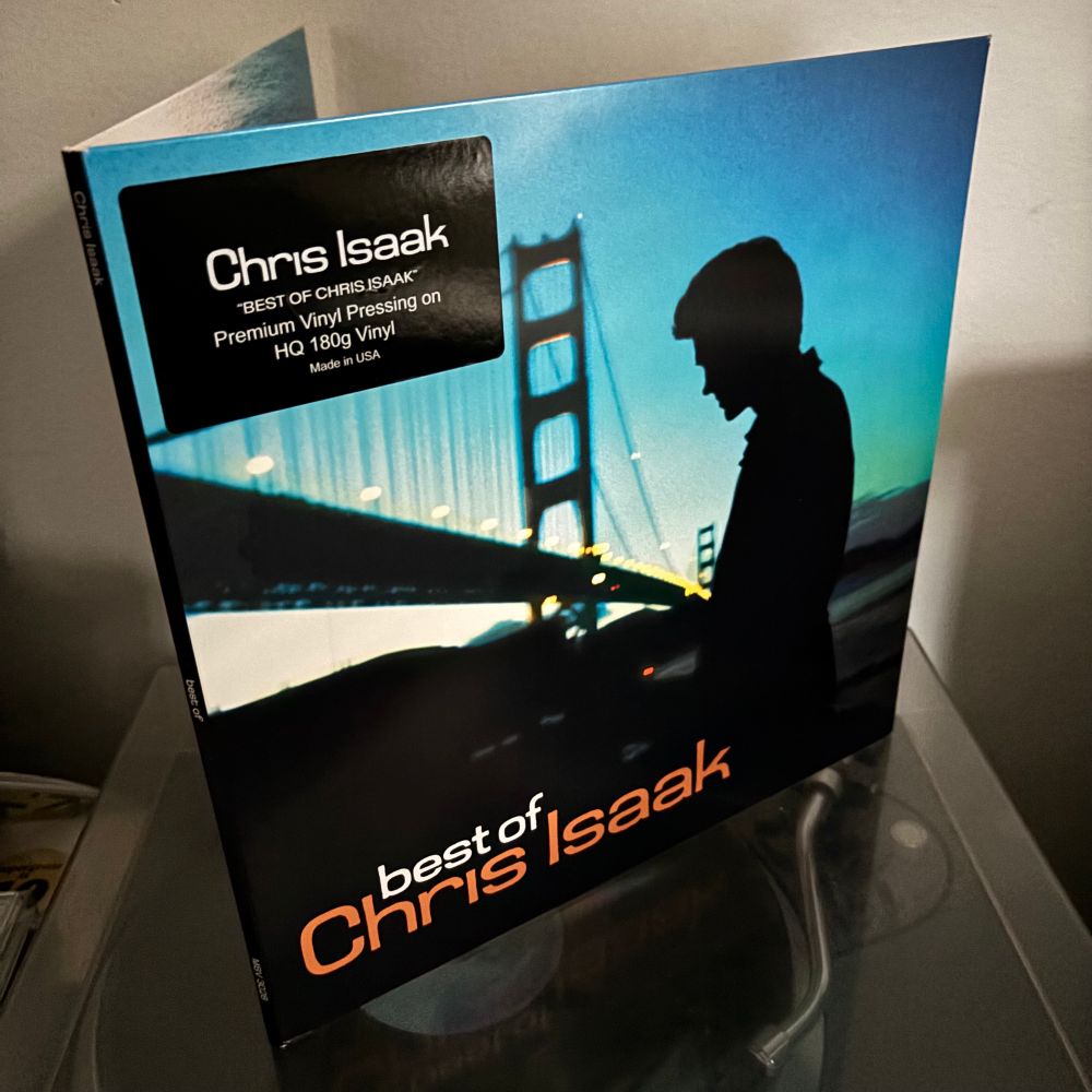 Chris Isaak Best of -LP:nsä kannessa tummana silhuettina auringon laskun aikaan Golden Gate Bridgen juurella.