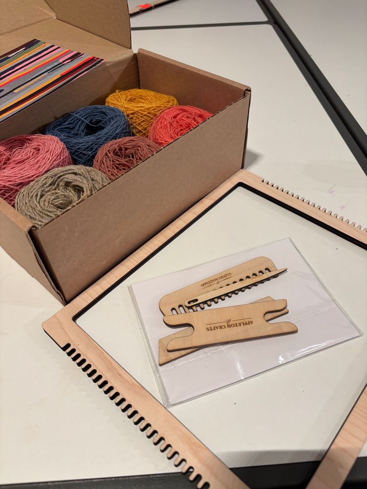 Empty loom and yarns in a box 