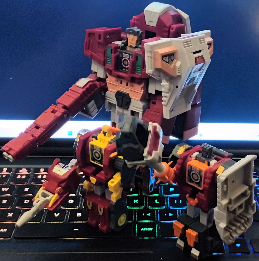 Three action figures that resemble Transformers from the late 1980s. In the back is "Tusker", a big guy with a long gun and a shoulder-mounted shield (and a flat head), on the left is "Fangro", who has a proportionally large gun, and on the right is "Tailclub", who has a very large spiked club and his own shield