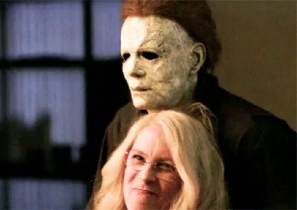 a man in a mask is standing next to a woman .