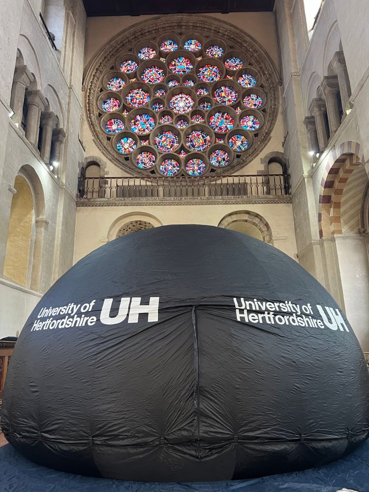 An inflatable planetarium underneath the stained glass windows of St Albans cathedral