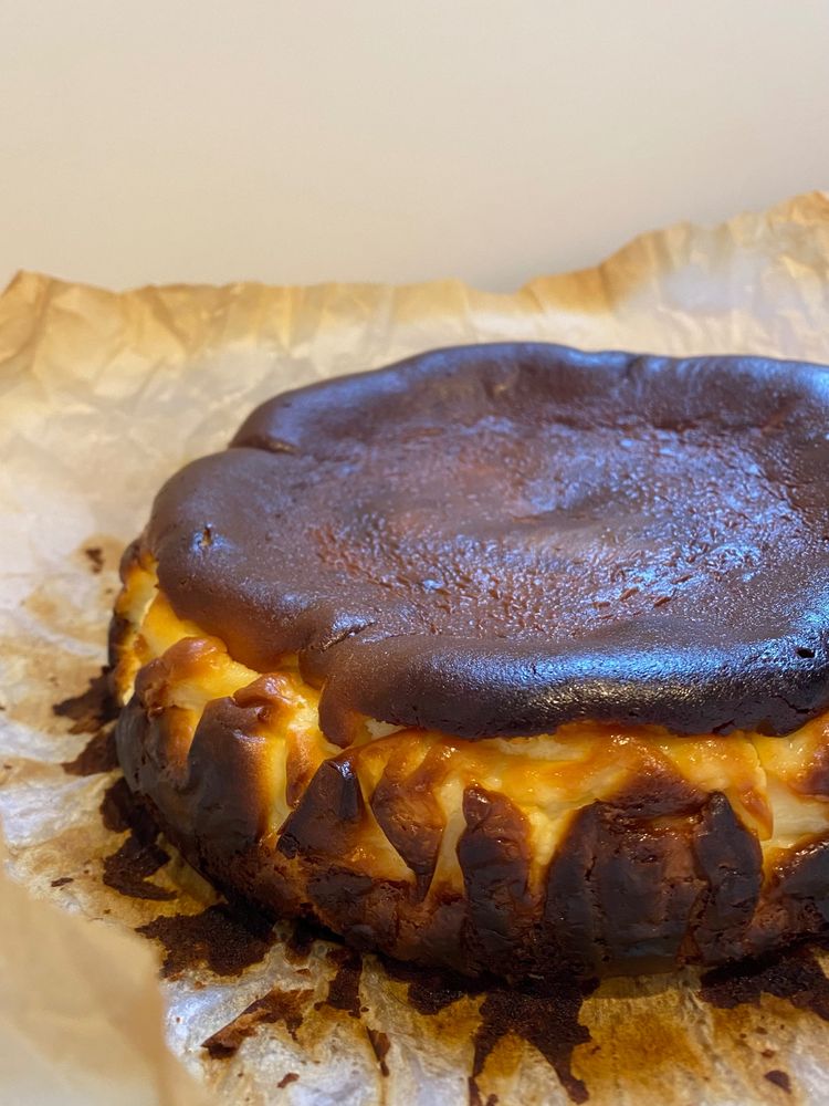 Photo of a browned basque cheesecake on parchment paper