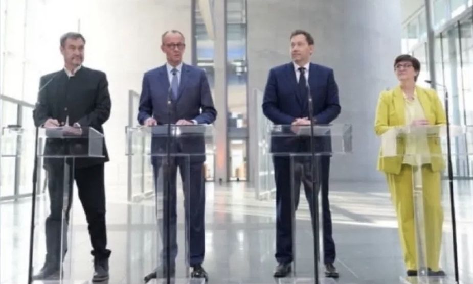 Söder, Merz, Klingbeil, Esken stehen hinter transparenten Pulten 