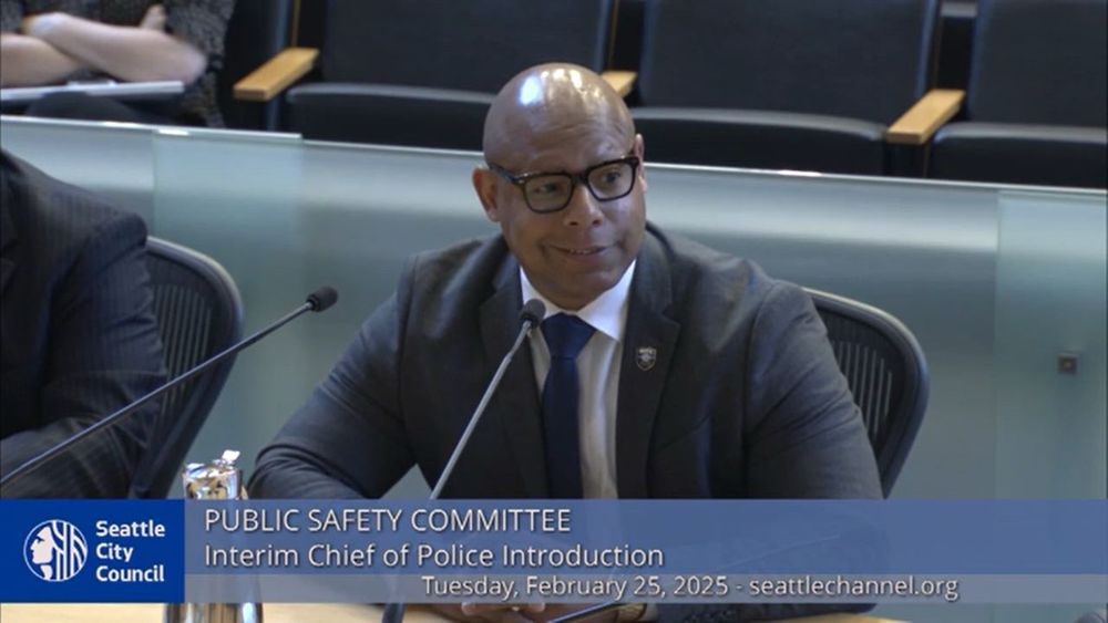 Shon Barnes at a Seattle City Council meeting sitting at a table