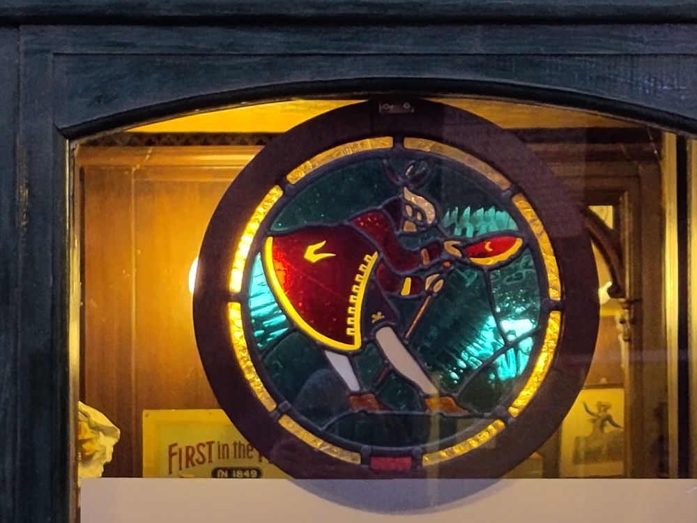 Circular stained glass sign showing an 18th century man doffing his cap (logo of Melbourne Brewery, Leeds which closed in 1960).
Leeds Museums and Galleries collections.