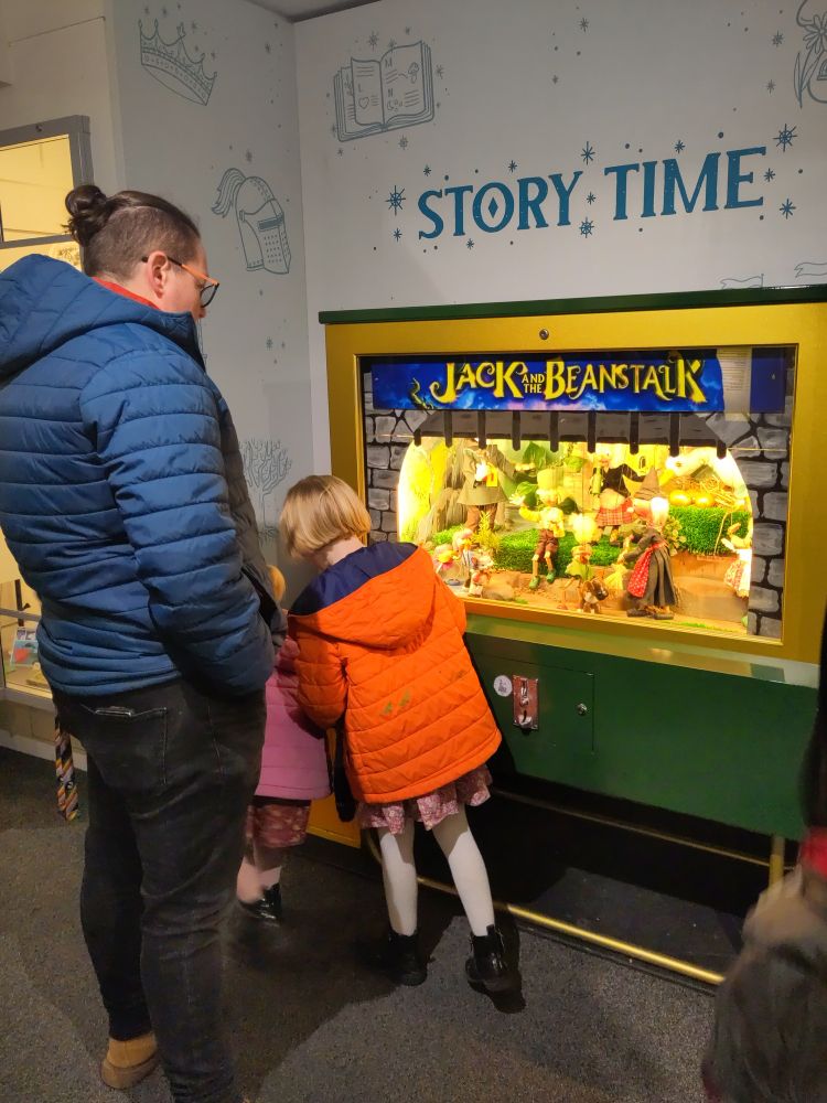 Adult and child watching a 1960s penny arcade machine of Jack and the Beanstalk using Pelham puppets in the exhibition at Abbey House Museum Leeds 