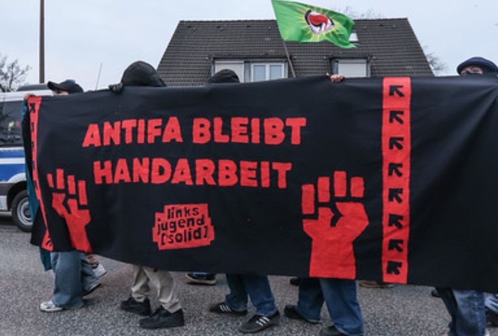 Ein schwarzes Seitentransparent auf dem in rot "Antifa bleibt Handarbeit" und "Linksjugend ['solid]" steht. 