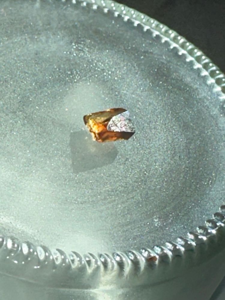 crystallized soy sauce salt with one facet reflecting sunlight glare