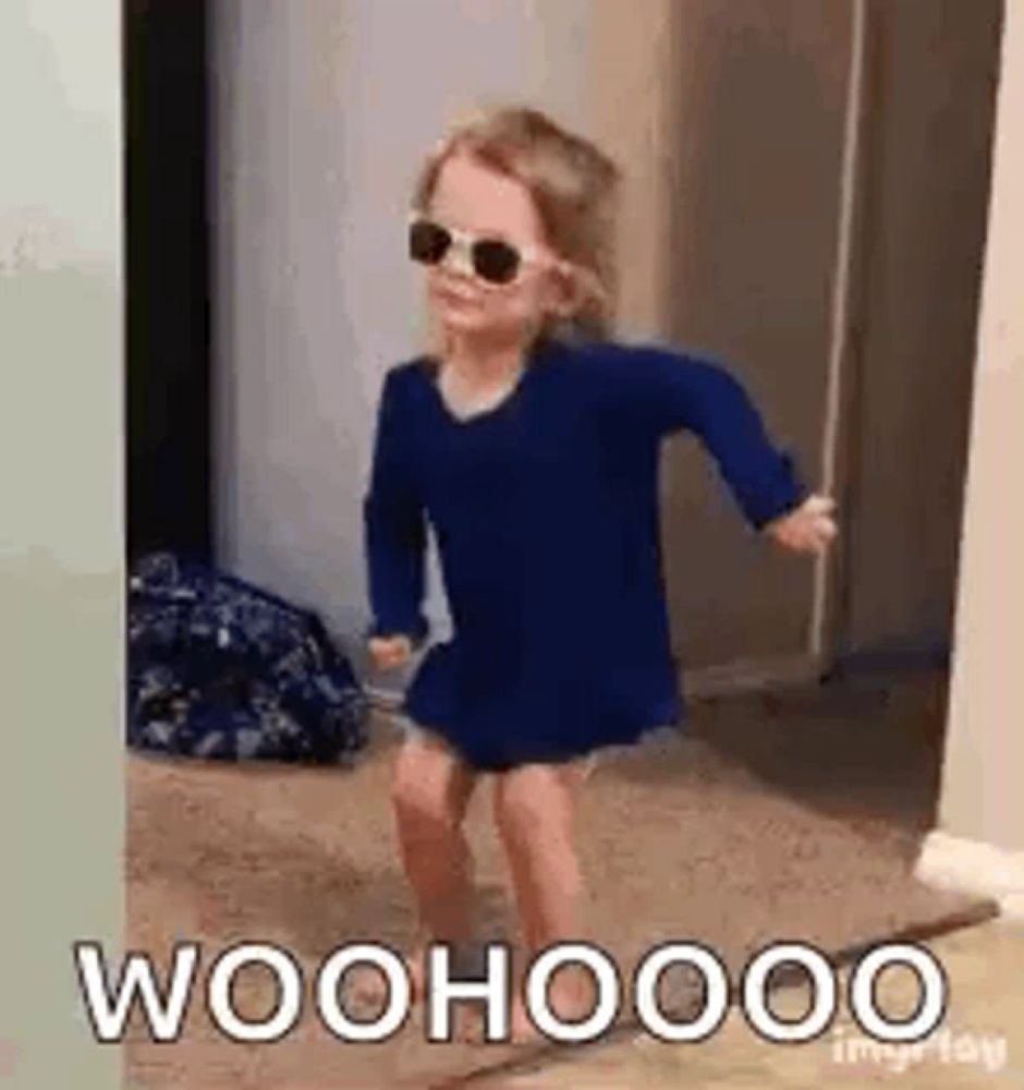 a little girl wearing sunglasses and a blue dress is dancing in a doorway .