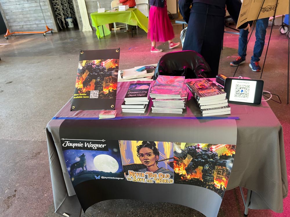 A table with a banner showing the name of the author (Jaymie Wagner) and several different books for sale. 