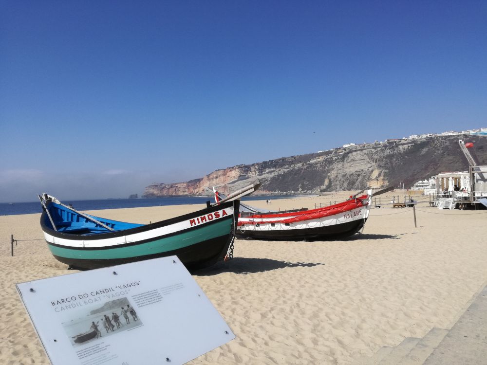2 Fischerboote am Strand, eines heißt Mimosa.
Im Hintergrund die Oberstadt.