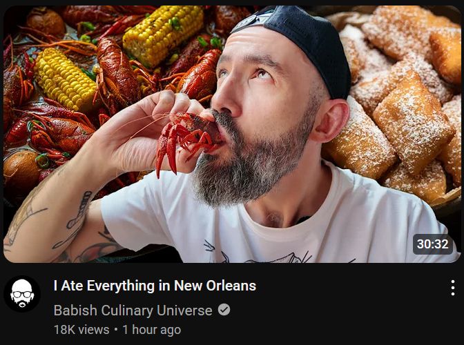 a screencap of a link to the latest Babish Culinary Universe video. Babish is sucking on a crawdaddy against a backdrop of other Louisiana cuisine. the video title is "I Ate Everything in New Orleans"  