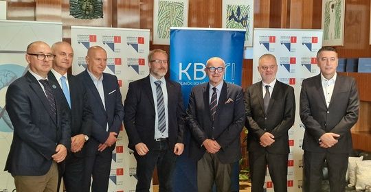 Gruppenfoto mit sieben Männern in Anzügen vor Bannern mit Logos verschiedener Institutionen. ©KBC Rijeka