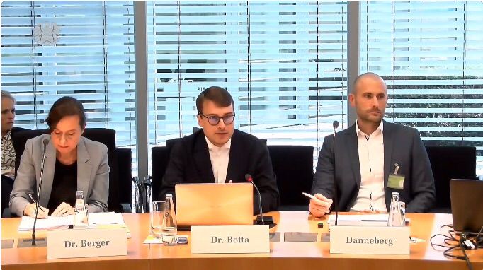 Bild von der Öffentlichen Anhörung im Innenauschuss. Zu sehen sind drei Sachverständige, unter anderem Jonas Botta.