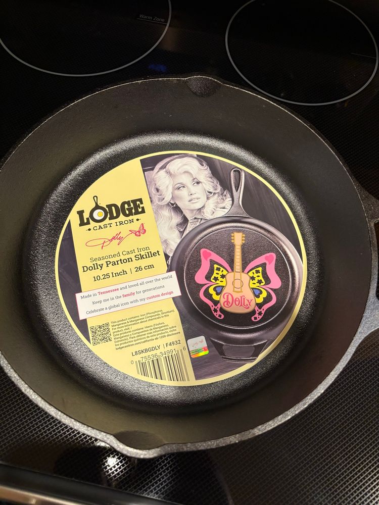 A lodge cast iron pan “Dolly Parton Skillet” the design on the bottom is a guitar with butterfly wings