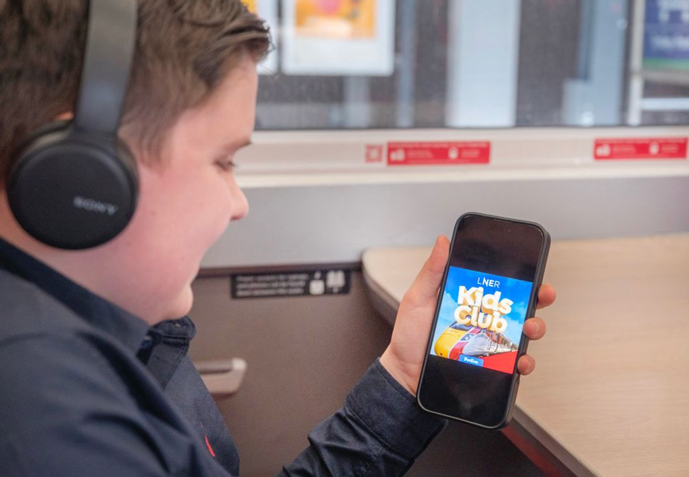 A child on an LNER train looking at the LNER kids club screen