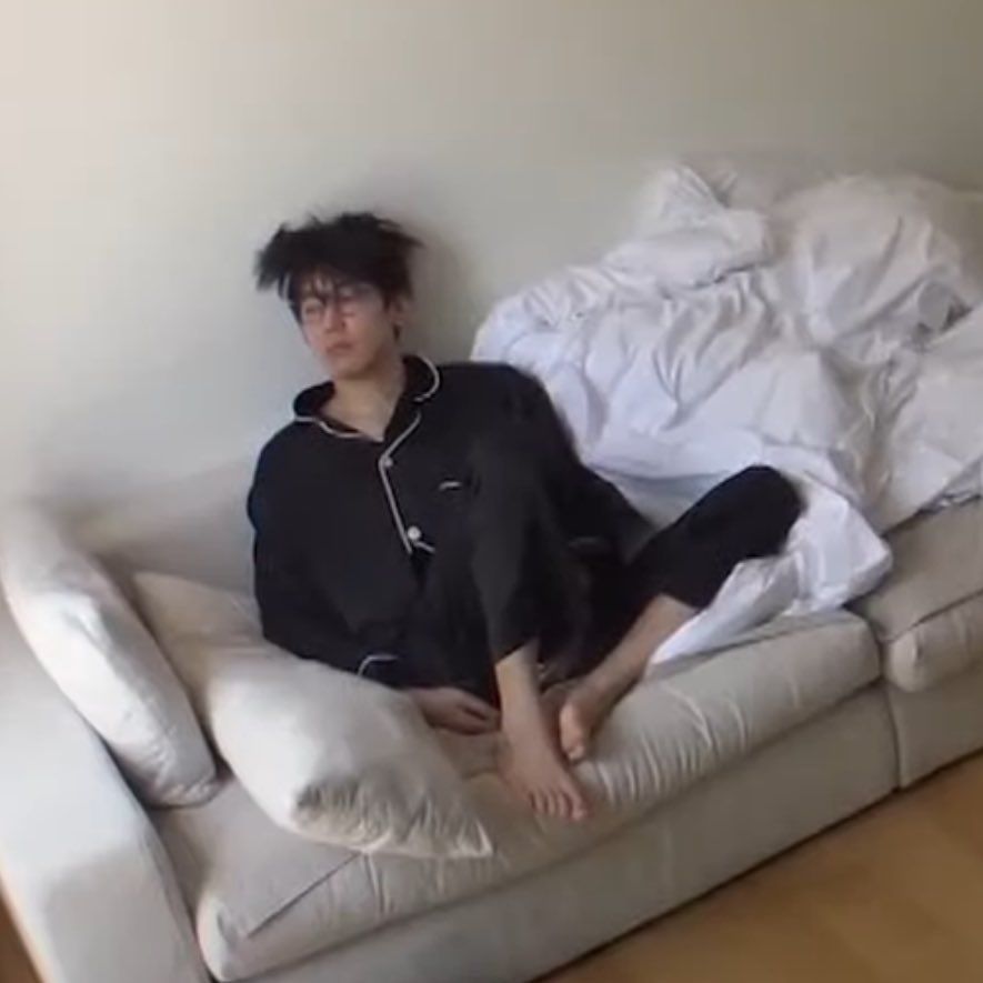 wonwoo from the kpop group, seventeen is the ultimate tired while sitting on a couch
