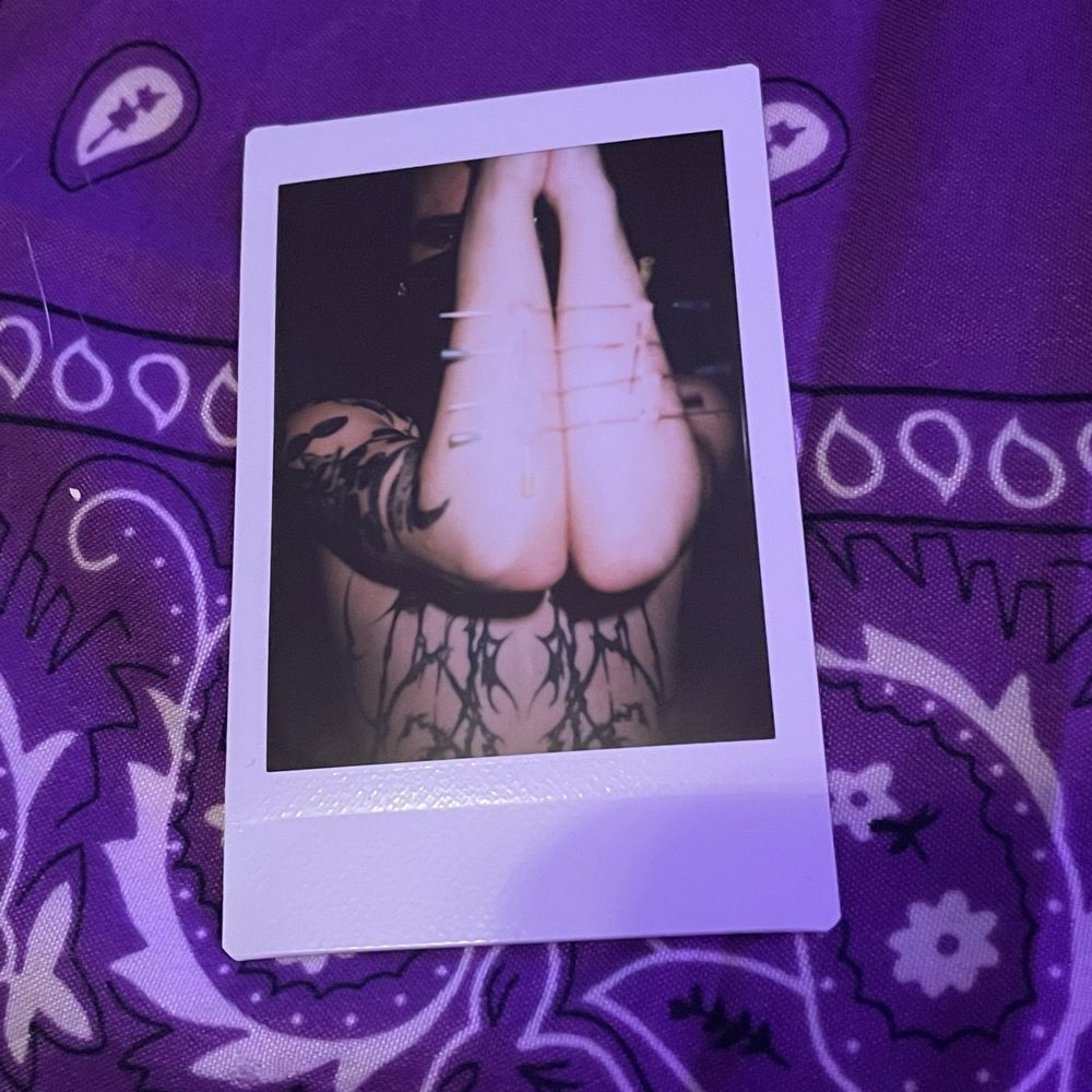 polaroid of boy mischief's arms, held in front of his face in the prayer position. they are bound together by 4 long needles pierced through his forearms