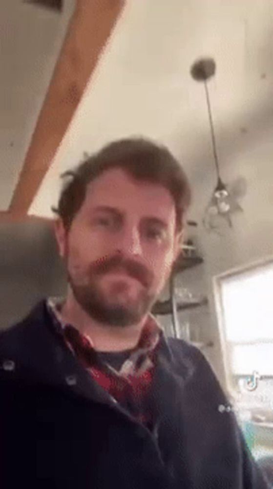 a man with a beard and mustache is standing in a kitchen