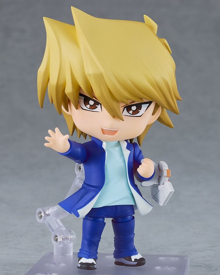A picutre of Yu-Gi-Oh! - Joey Wheeler Nendoroid with his Determined face. On one arm is his  Duel Disk, his hand clenched into a fist. His other hand is reaching out, fingers extended as he calls out an attack