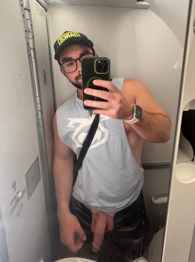 Person standing in plane bathroom with penis showing.