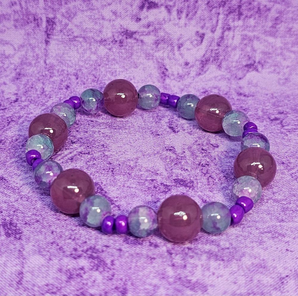 purple beaded bracelet on a purple marbled background