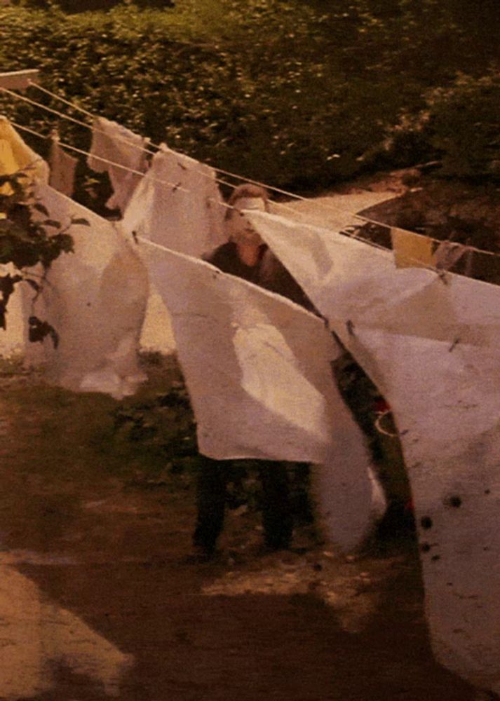 laundry hanging on a clothes line with a person standing in the background