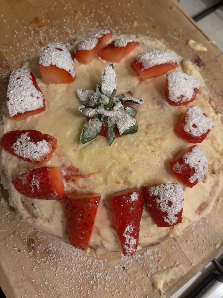 Close up of a cake made by my 15 yo decorated with cream and fresh strawberries 