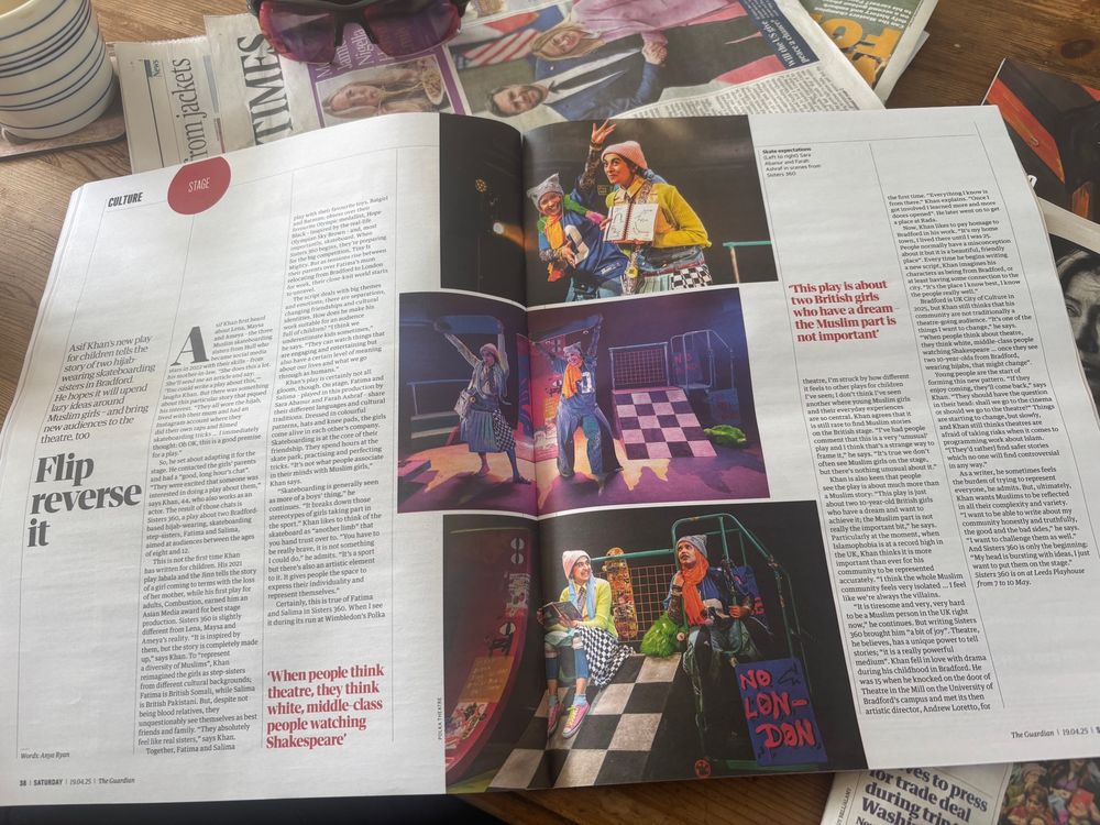 Photograph of a two page spread in a newspaper about Asif’s play Sisters 360 with bright colourful photos of two south Asian young women in hijabs on a colourful set 
