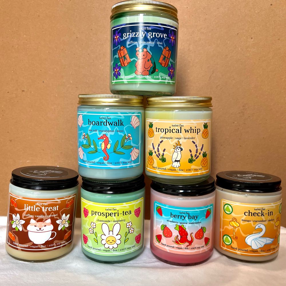 A pyramid stack of jarred Saint Fax hand poured vegan soy wax candles from left to right top to bottom the scents read
Grizzly Grove
Boardwalk, Tropical Whip
Little Treat, Prosperi-tea, Berry Bay, Check-in