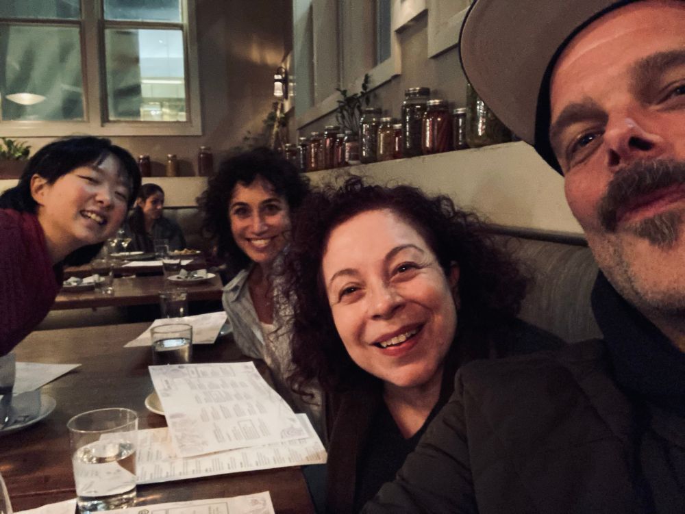 4 people at a table normal people light and angle of the photo are good and normal 