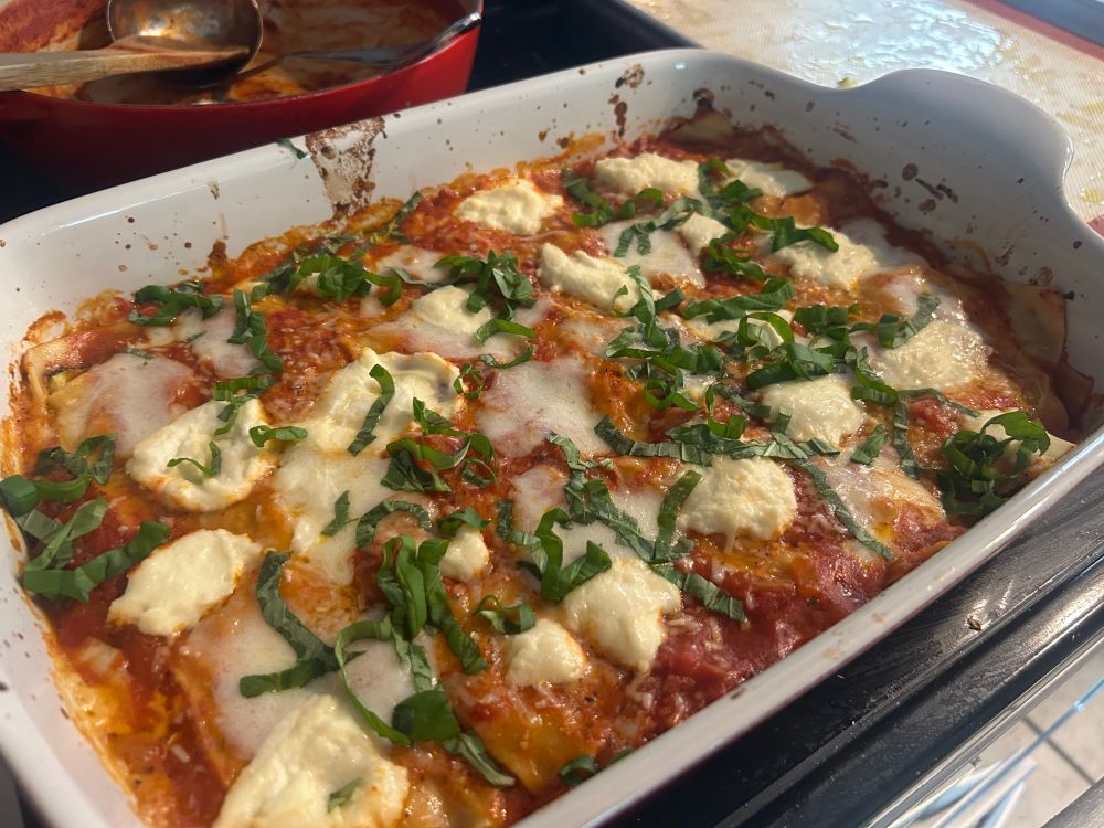A lasagne in a baking pan. Basil is sprinkled on top. 