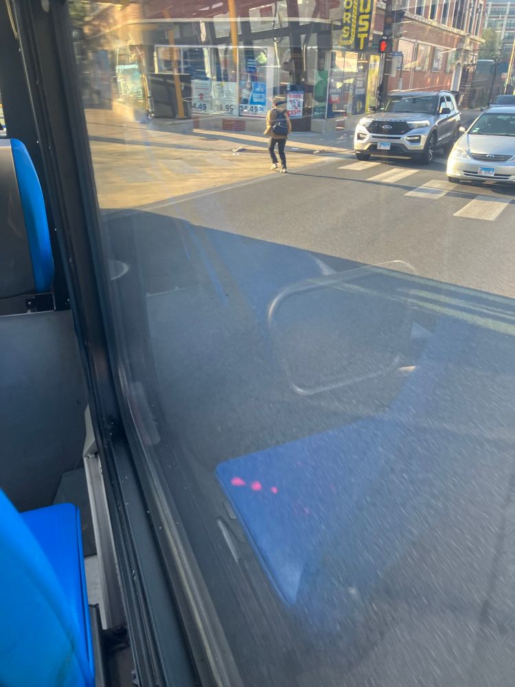 Photo out of a bus window of a large tan painted curb extension.