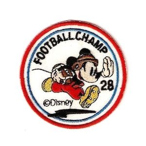 Mickey mouse running with football champ written across the top