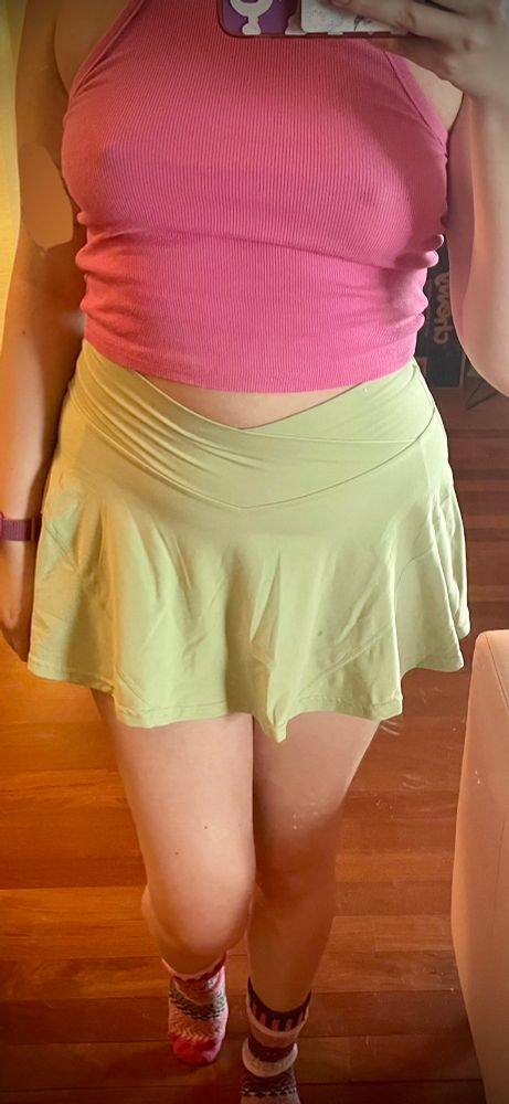 penny showing u their light green short skirt and their bright pink tank top with matching “mismatched” slouchy socks