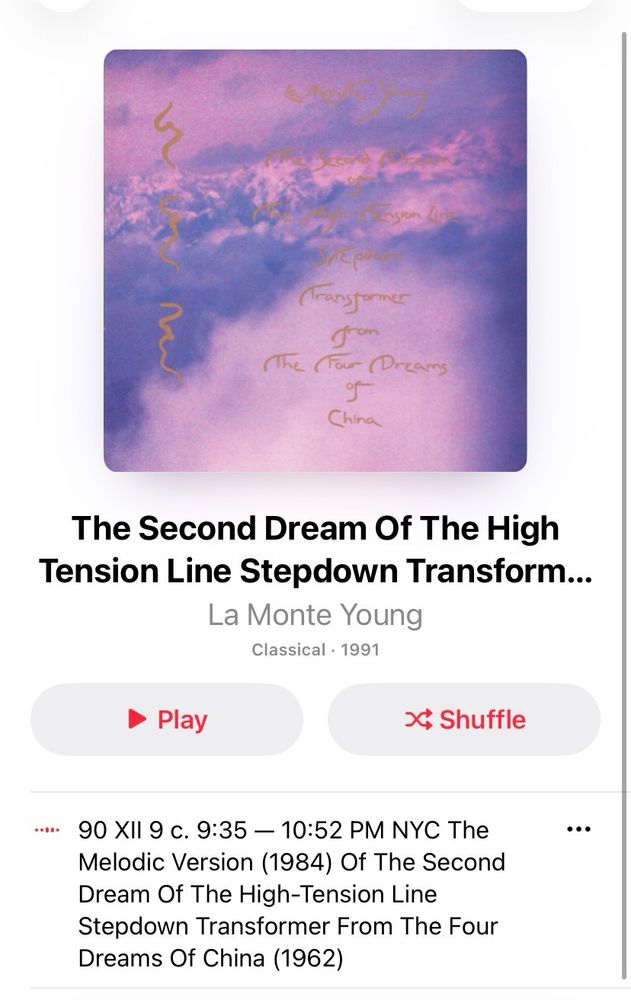 Screenshot of a music album on a streaming app. The album cover shows a cloudy purple and pink sky with handwritten gold text reading “La Monte Young – The Second Dream of the High Tension Line Stepdown Transformer from The Four Dreams of China.” Below the cover, the album title and artist are displayed: “The Second Dream Of The High Tension Line Stepdown Transformer from The Four Dreams of China” by La Monte Young, classified under Classical, released in 1991. Buttons for “Play” and “Shuffle” are visible, along with track details describing a 1984 melodic version recorded in New York City.