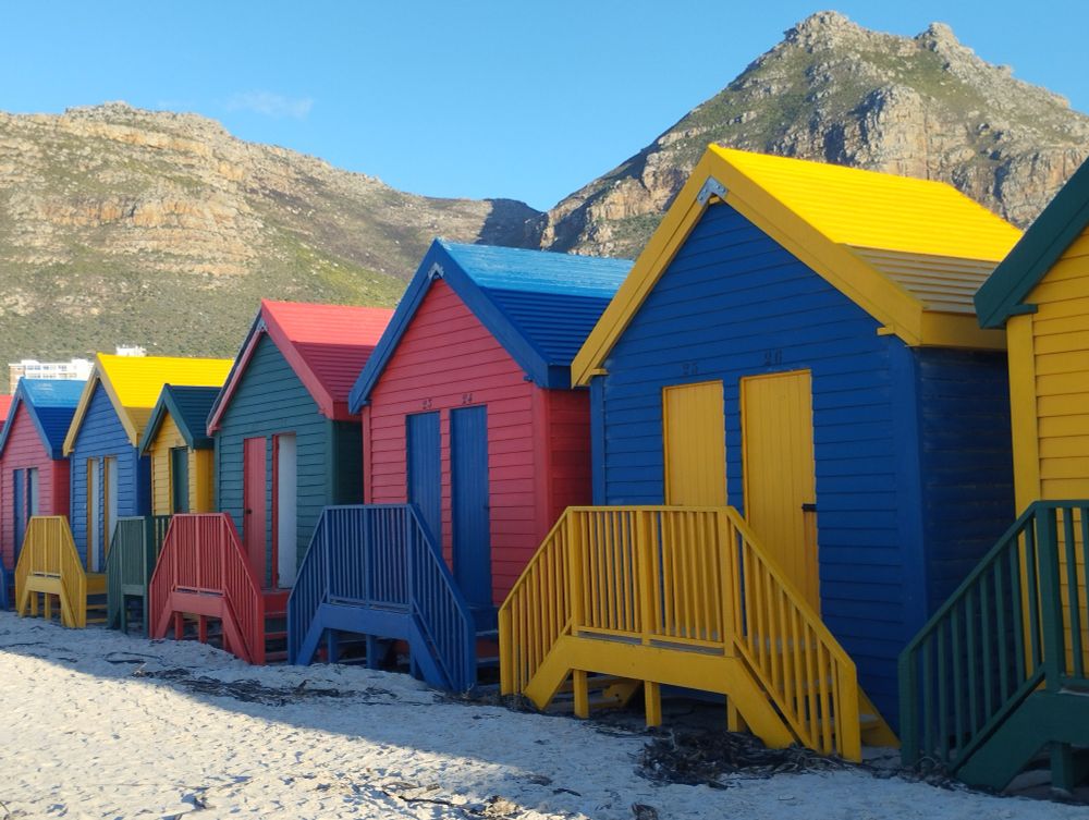 Cabanes en bois coloré devant un paysage de montagnes au Cap de bonne espérance 