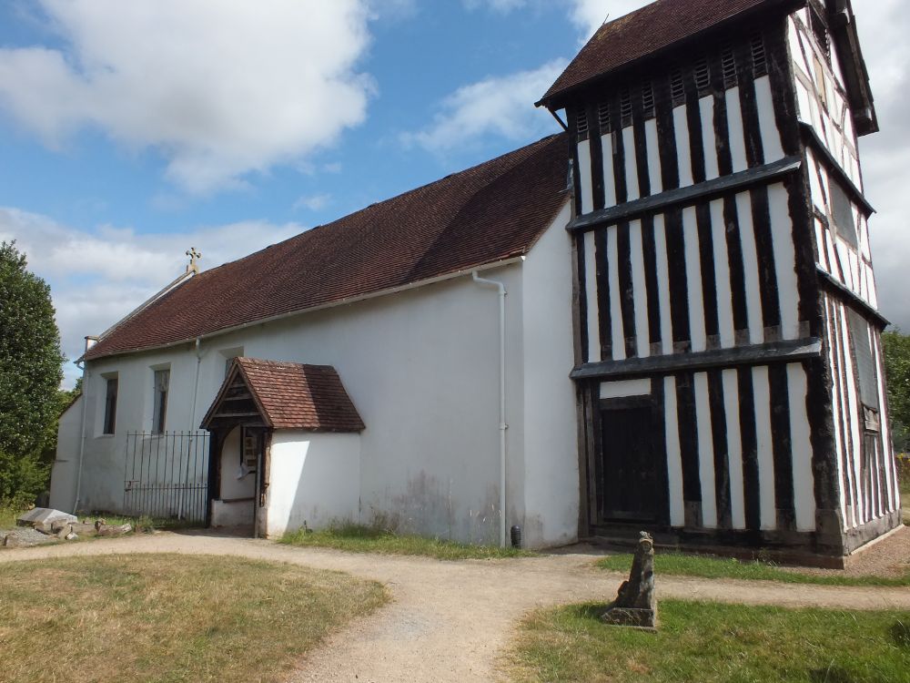 S side with porch, with timber-framed tower.