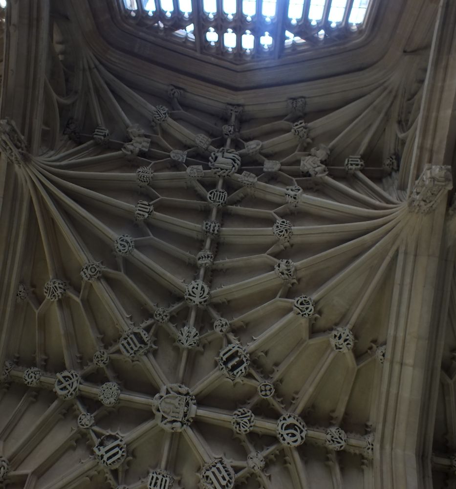 Second bay from E of Divinity School vault, centre boss is for John Kemp (d. 1454), archbishop of Canterbury, cardinal, and uncle of the patron, Thomas Kemp bishop of London. Around it is vernacular prayer "thank - god - of - al".

To S (above) is Lamb of God surrounded by arms of Henry Chichele (abp Canterbury d.1443, presumably All Souls' money), William Waynflete (bishop of Winchester and patron of William Orchard, Oxford's biggest buildings contractor, at Magdalene College), Walter Lyhart (bishop of Norwich), John Russell (Bishop of Lincoln from 7 July 1480) and the Universitu arms with "of q't Edw'r Rex" up the lateral rib