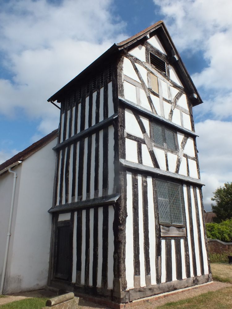 Warndon church tower from NW. upright studs on N side and E side ground storey, outward braces on upper two storeys of E side.