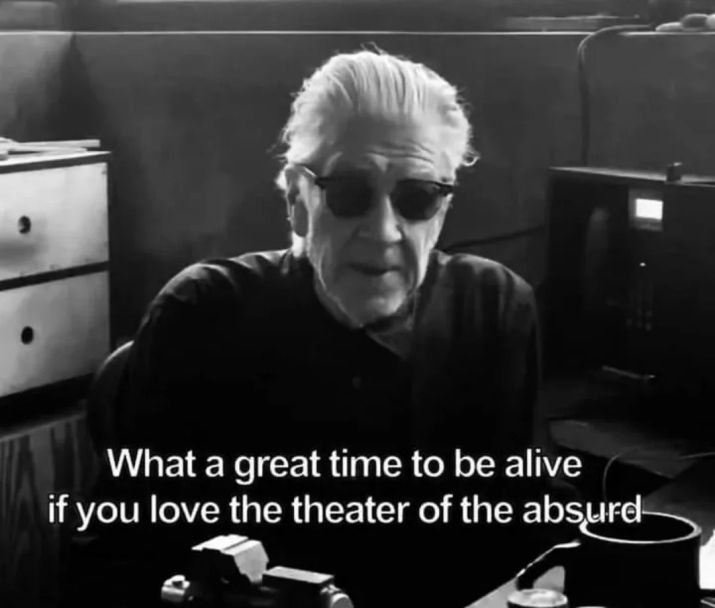 subtitle: "What a great time to be alive if you love the theater of the absurd." 
[A dark b/w image of David Lynch in an office, wearing sunglasses]