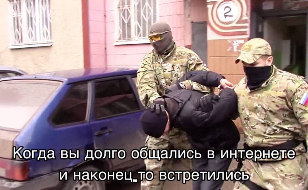 In the photo, two security officers in military uniform lead a man in handcuffs, bending him in half against the backdrop of the Russian outback. At the bottom there is an inscription in Russian “when you talked on the Internet for a long time and finally met”