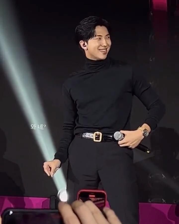 Namjoon on stage
He's wearing all balck clothes, à shiny belt and a turtle neck
A big watch on his wrist, he has his thumb on his belt