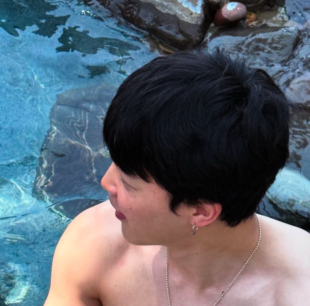 Jimin in water, looking to his right away from the camera.