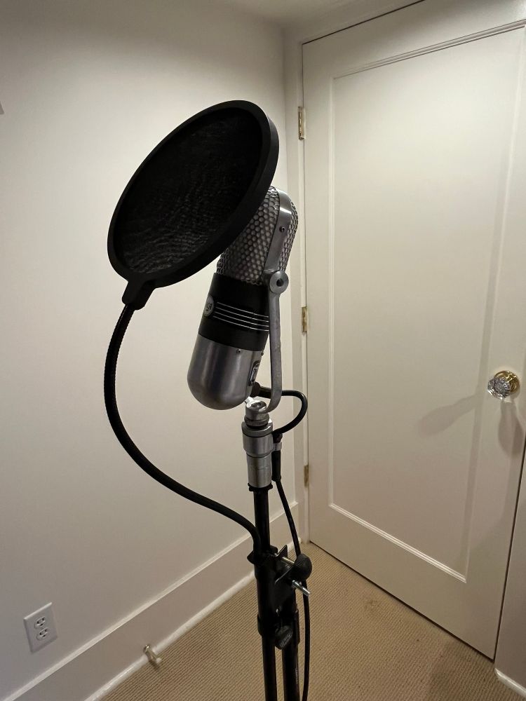 An RCA 77-DX microphone on a stand with a round pop filter in front of it
